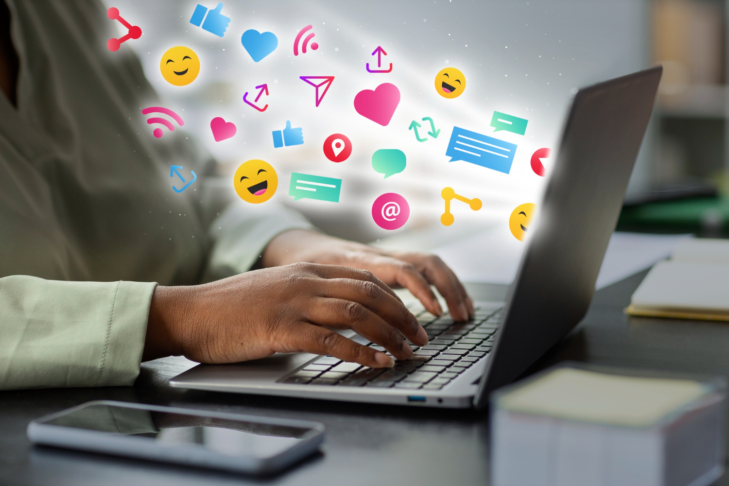Le mani di un uomo al PC mentre fuoriescono delle icone dei vari social e servizi di messaggistica.
